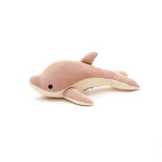 a pink stuffed dolphin laying on top of a white surface