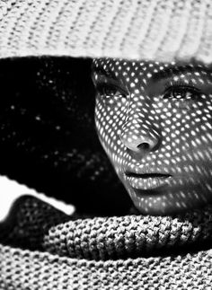 black and white photograph of a woman wearing a hat with her face covered by a scarf