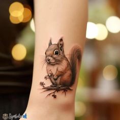 a small squirrel tattoo on the right side of the leg, it is sitting on top of a tree branch