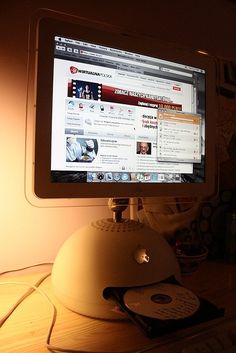 a desktop computer monitor sitting on top of a wooden desk next to a light bulb