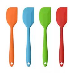 four different colored spatulas are lined up in the same row on a white background