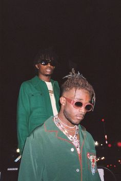 two men standing next to each other wearing sunglasses