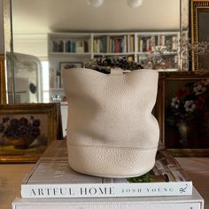 a white purse sitting on top of two books