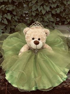 a teddy bear wearing a green tutu with a tiara