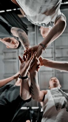 a group of people stacking their hands together