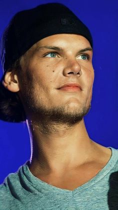 a young man with a ponytail under his head looking up at something blue in the background