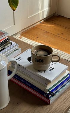 a stack of books and a coffee mug on a table