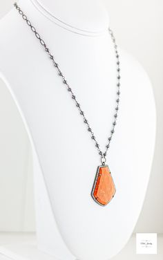 Stand out in this beautiful eye-catching burnt orange resin, hematite and cubic zirconia necklace. Bold and bright it is ready for your next event and bound to get you noticed! The beautiful uniquely shaped burnt orange resin bezel has shimmering ribbons of saffron yellow throughout and it is framed by sparkling cubic zirconia stones.Stunning, bright and shimmering faceted cherry burnt orange resin framed by black gold-plated sterling silver bezel that is studded with sparkling cubic zirconia. Black gold-plated short and long oval link chain. Beautiful shimmering silvery black hematite beads wrapped in black gold-plated chain. Gunmetal-plated brass lobster clasp for a secure and comfortable fit. 18.5 inches long. Only one available! Make this gorgeous limited edition necklace yours today! Orange Gemstone Pendant Jewelry, Orange Carnelian Gemstone Necklace, Elegant Orange Pendant Necklaces, Orange Gemstone Pendant Necklace, Orange Faceted Jewelry Gift, Elegant Long Orange Necklace, Orange Gemstone Necklaces As A Gift, Orange Large Pendant Jewelry, Orange Faceted Carnelian Necklaces