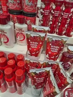 many different types of red and white products on display in a store shelf with snowflakes all over them