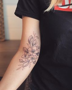 a woman's arm with a flower tattoo on the left side of her arm