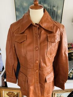 Bottom Line Brown Vinyl/ Faux Leather JacketMarked size 16 fits like a smaller mediumJacket measures 27” long with 22” sleeve when lying flat there’s 16.5” between shoulder seams and 18” in the chest SHIPPING estimates are based upon USPS Priority Flat rate boxes. Please feel free to contact me with your zip code to get an accurate shipping cost.**INTERNATIONAL CUSTOMERS** Im happy to ship overseas, so please feel free to contact me with your shipping information and within 24 hours I will do my Vinyl Jacket, Floral Apron, Cute Aprons, Vintage Kitchenware, Half Apron, Old Love, Zip Code, Im Happy, Faux Leather Jackets