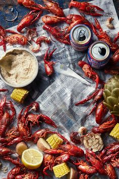 crawfish, corn on the cob and beer are laid out on newspaper