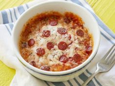 a white bowl filled with pepperoni and cheese on top of a blue and white towel