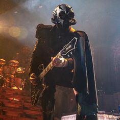 a man dressed as darth vader with a guitar in his hand on stage