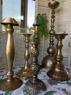 three brass candlesticks sitting on top of a table