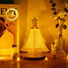 a lighted christmas tree sitting on top of a table next to two vases filled with flowers