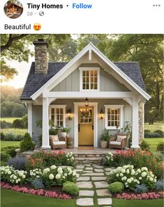 a small house with flowers and plants around the front door is featured on instagram