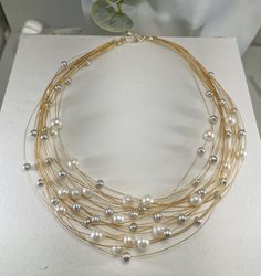 "This Modern & Classical multi-strands pearls necklace Titled \"21 strands of love\", measures from 17\"-19\"(multi-strands)long, it is made with two-tone pearls: AA grade white pearl 7-8 mm, and AAA Silver gray pearl 4mm. 14k gold color elegant cables. hand-made classic lobster claw clasp. it is the best gift for mom and wife for the anniversary event, wedding gift, Christmas gift,s, and Thanksgiving gift. This necklace is the Seattle Art Museum gift shop's selected piece" Luxury Yellow Gold Pearl Necklace For Celebration, Multi-strand Pearl Necklace With Pearl Charm, Multi-strand Pearl Drop Necklace, Luxury Multi-strand Pearl Necklace As Gift, Multi-strand Pearl Necklaces For Gifts, Elegant Multi-strand Necklace For Anniversary, Gold Multi-strand Pearl Necklace, Multi-strand Pearl Necklace For Gift, Elegant Multi-strand Necklace For Gift