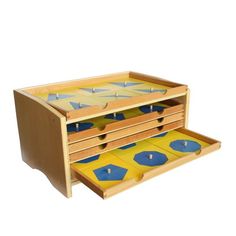 a wooden toy chest with two drawers and blue circles on the top, in front of a white background