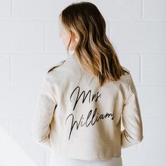 a woman wearing a white jacket with the words mr and mrs william written on it