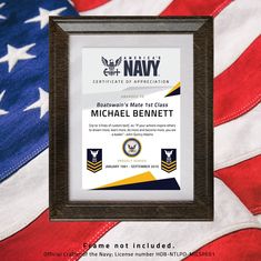 a framed certificate is on top of an american flag with the navy seal in it