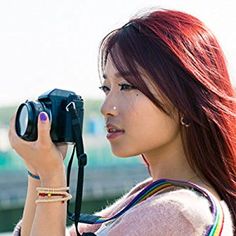 a woman with red hair is holding a camera