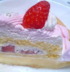 a piece of cake with pink frosting and a strawberry on top