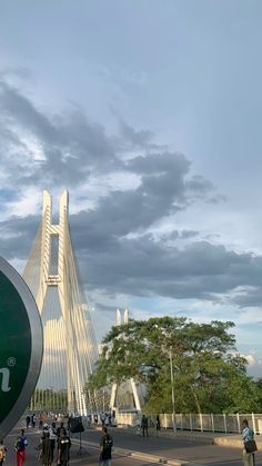 many people are walking around in front of a bridge