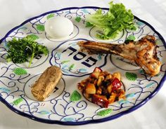 a blue and white plate topped with meat and veggies next to an egg