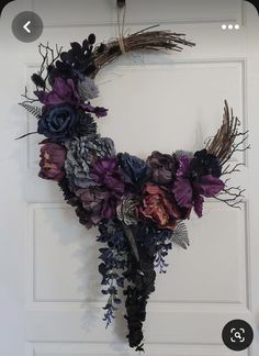 a wreath made out of dried flowers hanging on a door