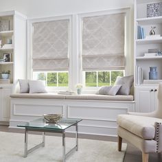 a living room filled with furniture and windows covered in roman blind shades on the windowsill