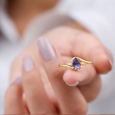 Product Details Introducing the stunning Minimal Teardrop Tanzanite Ring, featuring a 5x7 mm Tanzanite stone in a Prong Setting on a Bypass Shank. This exquisite Tanzanite Solitaire Ring is sure to make a statement and be the ultimate choice for your beloved partner. Product Information SKU SHP-RINGS0821162053 Width 2.9 mm Height 6.4 mm Weight 1.92 gm (Approximate) TANZANITE INFORMATION No.of Stones 1 Pieces Total Weight 0.84 Carat (Approximate) Dimension(approx) Pear-5X7 mm-1 Pcs Color Blue Cut Teardrop Stone Ring, Bypass Engagement Ring, Pear Cut Ring, Tanzanite Stone, Jewelry Accessories Ideas, Tanzanite Ring, Tanzanite Gemstone, Signature Jewelry, Finger Rings