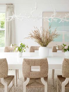 a dining room table with chairs and vases on it