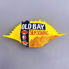 an old bay seasoning sticker on the side of a gray wall with yellow and red designs