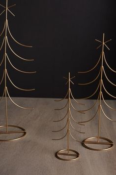 three metal christmas trees sitting on top of a table