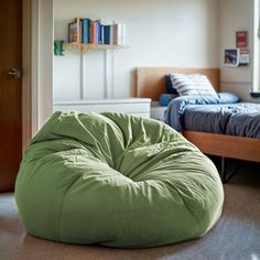 a bean bag chair sitting on the floor in a bedroom next to a twin bed