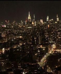 an aerial view of the city at night with lights and skyscrapers in the background