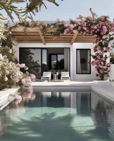 the pool is surrounded by pink flowers and greenery