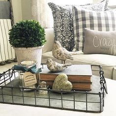 a living room filled with lots of furniture and pillows on top of a coffee table