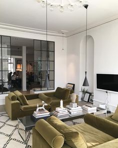 a living room filled with furniture and a flat screen tv mounted to the wall above it