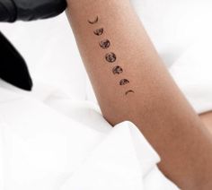 a woman's arm with three phases of the moon on it