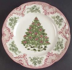 a plate with a christmas tree on the front and side, sitting on a black surface