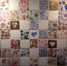 a tiled wall covered in lots of different colored tiles with hearts and flowers on them