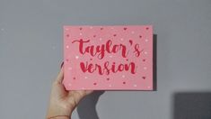 a person holding up a pink card with the words taylor's version written on it