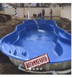 an above ground swimming pool being constructed in a backyard with people standing around the pool