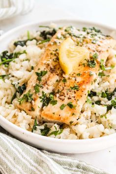 a white bowl filled with rice and meat covered in lemon wedged garnish