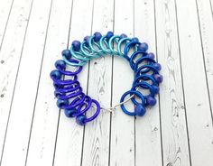 a bracelet with blue and purple spirals on it sitting on a white wooden floor