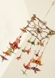 an origami mobile hanging from the ceiling with paper cranes attached to it's sides