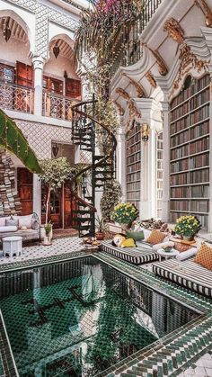 an indoor swimming pool in the middle of a living room filled with furniture and bookshelves