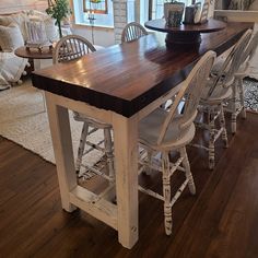 a kitchen table with chairs around it in the middle of a living room and dining area